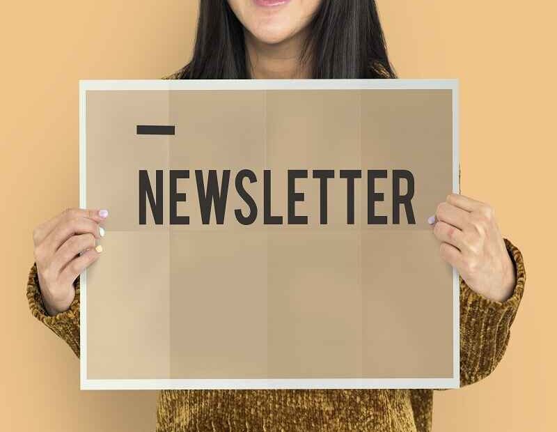 Person holding a sign with the word 'Newsletter,' representing email subscriptions and newsletter management.